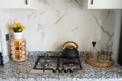 a kitchen counter with a stove with a tea kettle on it at Modern 2BR, Pool Access, Fast Wi-Fi in Marrakech