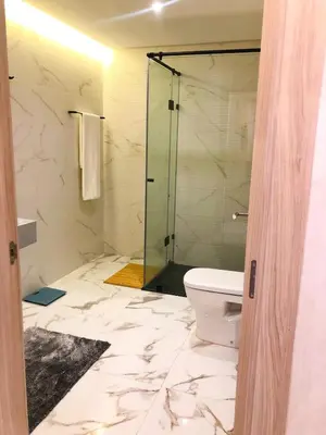 a bathroom with a toilet and a glass shower at Modern 2BR, Pool Access, Fast Wi-Fi in Marrakech
