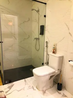 a bathroom with a toilet and a glass shower at Modern 2BR, Pool Access, Fast Wi-Fi in Marrakech