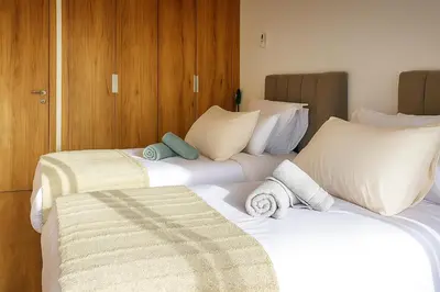 a bedroom with two beds with white sheets and pillows at Noria Golf - séjour chic et zen à Marrakech in Marrakech