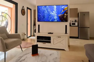 a living room with a flat screen tv on the wall at Noria Golf - séjour chic et zen à Marrakech in Marrakech
