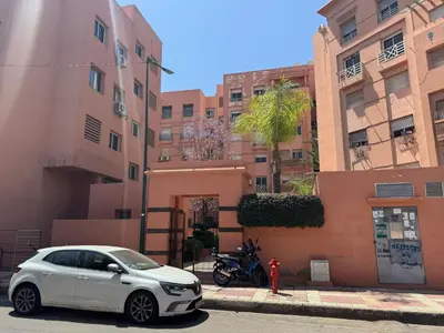 a white car parked next to a red fire hydrant at Al acadimya in Marrakech