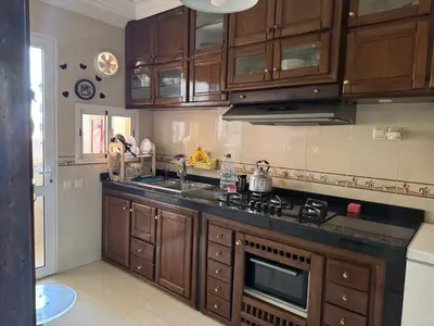 a kitchen with wooden cabinets and a stove top oven at Al acadimya in Marrakech