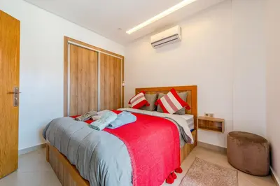 a bedroom with a bed with a red blanket at Warm Nest 5 Central And Peaceful in Marrakech