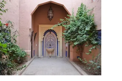 an entry to a building with a gate and a street at Riad Marrakech - Piscine -Wifi- résidence qarya essyahia in Marrakech