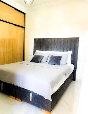 a bedroom with a large bed with a wooden headboard at Marrakech Riad in Marrakech