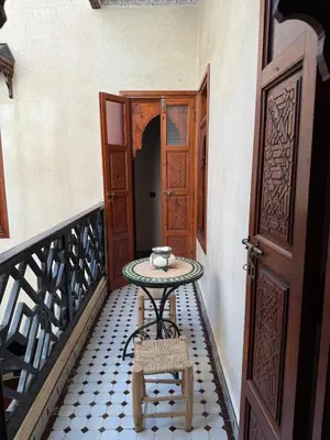 a small table on a balcony next to a door at Riad El Wiam in Marrakech