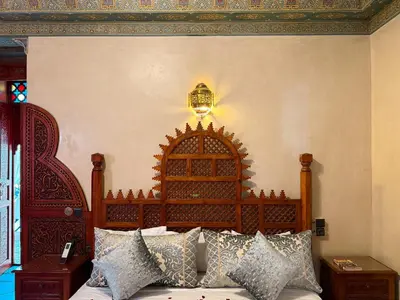 a bedroom with a wooden bed with pillows on it at Riad El Wiam in Marrakech