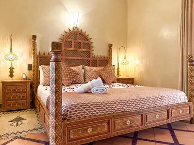 a bedroom with a large bed with a wooden headboard at Riad El Wiam in Marrakech