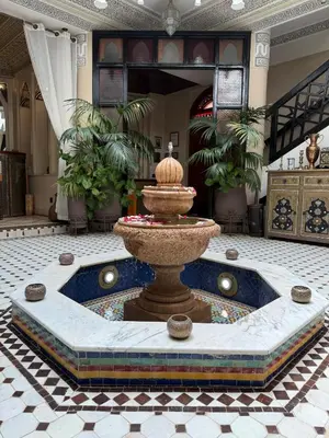 a fountain in the middle of a room at Riad El Wiam in Marrakech