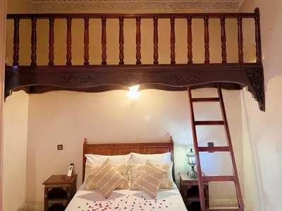 a bedroom with a wooden bunk bed with a ladder at Riad El Wiam in Marrakech