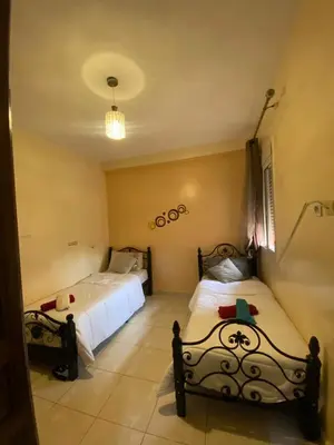a bedroom with two beds and a chandelier at Marrakech Gateway in Oulad Akkou
