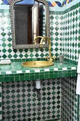 a bathroom sink with a mirror and a green counter top at dar sarsar airport 2 in Marrakech