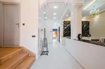 a hallway with white walls and a staircase with a stool at Villa 4 bedrooms with private pool in Marrakech in Marrakech