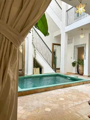 a swimming pool in the middle of a house at Riad Dar Rafaël in Marrakech