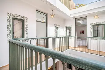 a balcony with white walls and a green railing at Riad Dar Rafaël in Marrakech