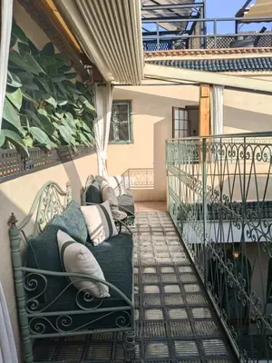 a porch with a couch on a balcony at Riad Dar Nana in Marrakech
