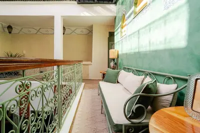 a balcony with a bench and a table at Riad Dar Nana in Marrakech