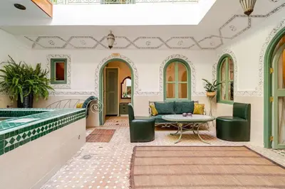 a living room with a pool and a table and chairs at Riad Dar Nana in Marrakech