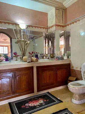 a bathroom with a toilet and a large mirror at Villa floor Espace ouvert in Marrakech