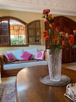 a vase with flowers on a table in a living room at Villa floor Espace ouvert in Marrakech