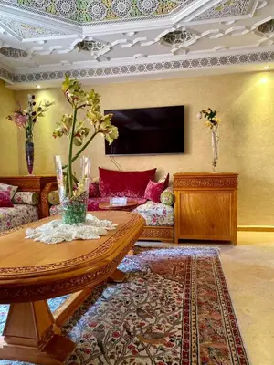 a living room with a table and a couch at Villa floor Espace ouvert in Marrakech