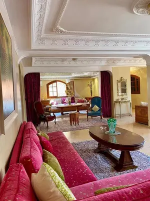 a living room with a red couch and a table at Villa floor Espace ouvert in Marrakech