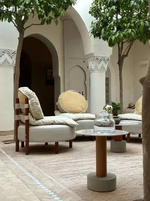a room with chairs and a table and trees at Riad Djannaat Exceptional private riad pool staff in Marrakech