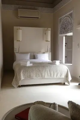a bedroom with a large white bed with a window at Riad Djannaat Exceptional private riad pool staff in Marrakech