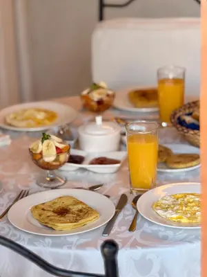 a table topped with plates of breakfast food and orange juice at Riad Aguaviva in Marrakech
