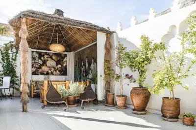 a patio with chairs and potted plants in front of a building at Riad Aguaviva in Marrakech