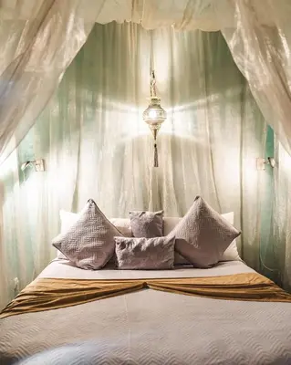 a bedroom with a canopy bed with white pillows at Riad Aguaviva in Marrakech