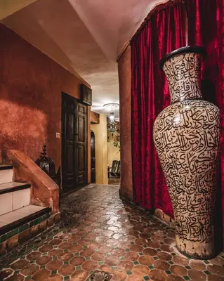 a large vase sitting in a room with red curtains at Riad Aguaviva in Marrakech