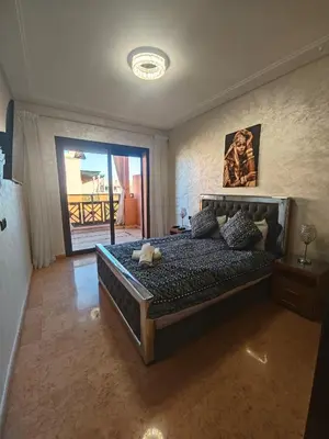 a bedroom with a bed with a teddy bear on it at Ennaim in Marrakech