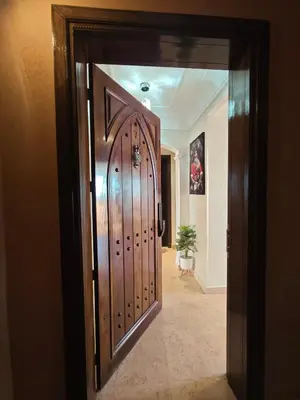 a large wooden door in a room with a hallway at Ennaim in Marrakech