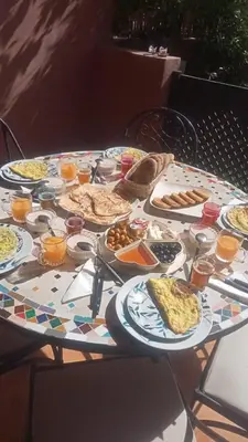 a table filled with plates of food and drinks at My Palm House Marrakech avec piscine privée in Marrakech