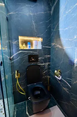 a bathroom with a black toilet in a blue tiled wall at Luxury apartment with jaccuzi in Marrakech