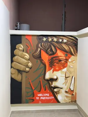 a wall with a painting of a man holding a sign at Luxury apartment with jaccuzi in Marrakech