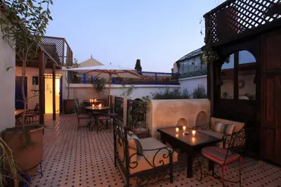 an outdoor patio with tables and chairs and lights at Riad Alma Mouassine in Marrakech