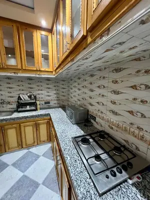 a kitchen with wooden cabinets and a stove top oven at Appartement spacieux marocain traditionnel familial in Marrakech