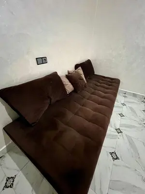 a brown couch sitting in the corner of a room at Appartement spacieux marocain traditionnel familial in Marrakech