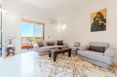 a living room with two couches and a table at Appartement Malika Gueliz in Marrakech
