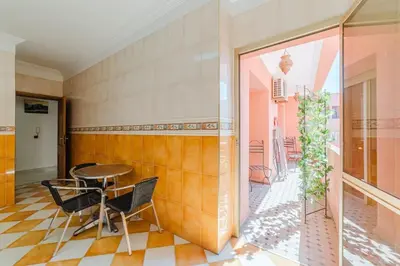 a dining room with a table and chairs and a patio at Appartement Malika Gueliz in Marrakech