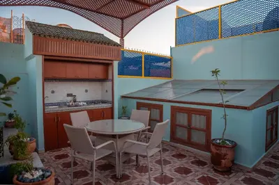 a patio with a table and chairs and a kitchen at Charming Private Riad in Marrakech
