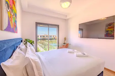 a bedroom with a bed and a window with a view at New! Appt moderne avec terrasse et vue piscine in Marrakech
