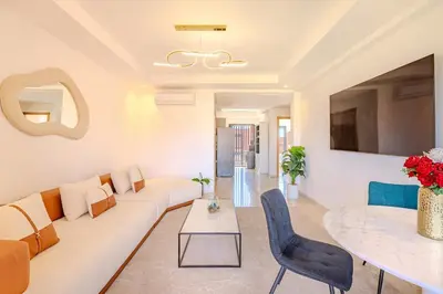 a living room with a white couch and a table at New! Appt moderne avec terrasse et vue piscine in Marrakech