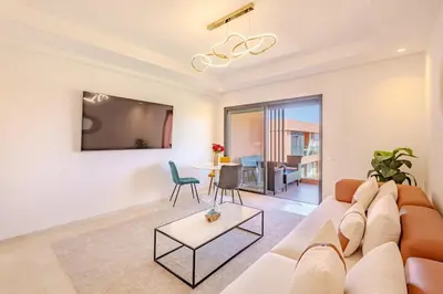 a living room with a couch and a table at New! Appt moderne avec terrasse et vue piscine in Marrakech