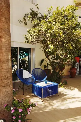 a blue chair and a table next to a tree at Maison d'hôte Darkom Kech in Marrakech