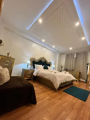a bedroom with a large bed and two tables and a couch at Maison d'hôte Darkom Kech in Marrakech