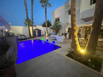 a pool in the middle of a courtyard with palm trees at Maison d'hôte Darkom Kech in Marrakech